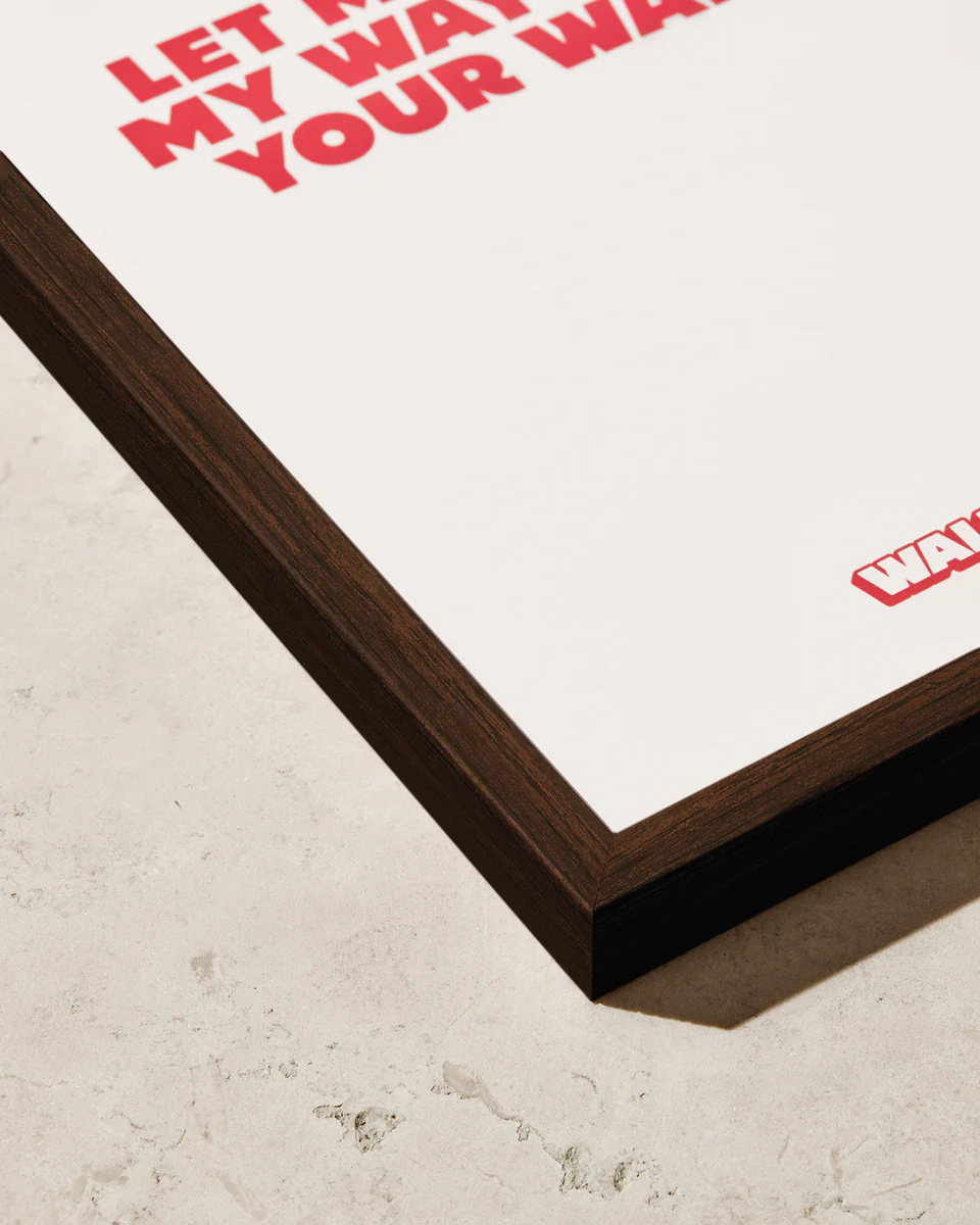 Close-up of the Frame Dark Oak corner with bold red text on a light textured background, giving a luxury Scandinavian feel. The text partially reads LET MY WAY and YOUR WAY, with a glimpse of a logo at the bottom right.