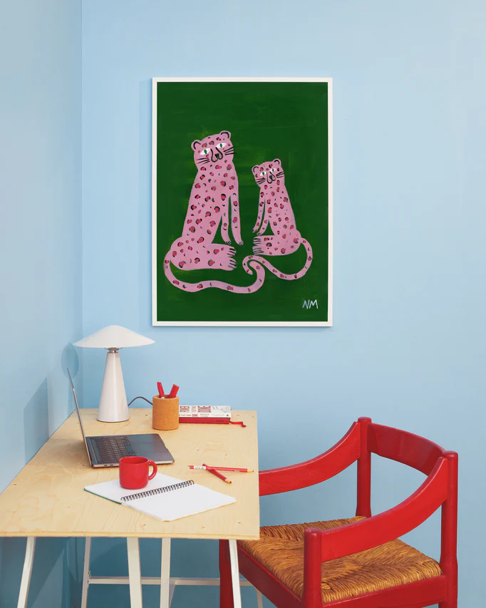 interior image of the "Leopards in Pink Poster" hanging on a blue wall in a home office 