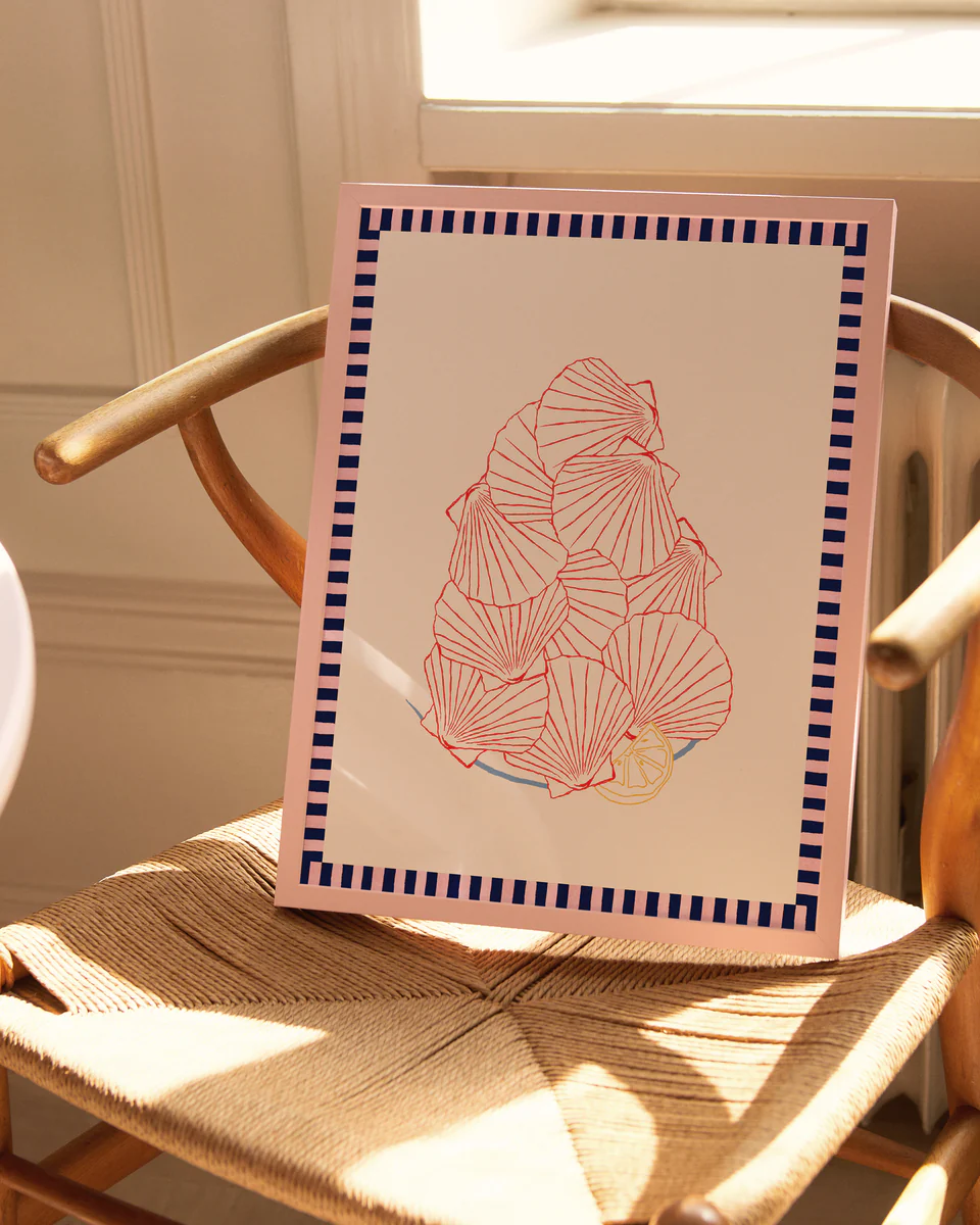 The Saint-Jacques du Marché Poster features abstract red and yellow floral shapes created with a collage technique, bordered by a blue and pink geometric pattern, resting on a wooden chair where sunlight from a nearby window casts gentle shadows.