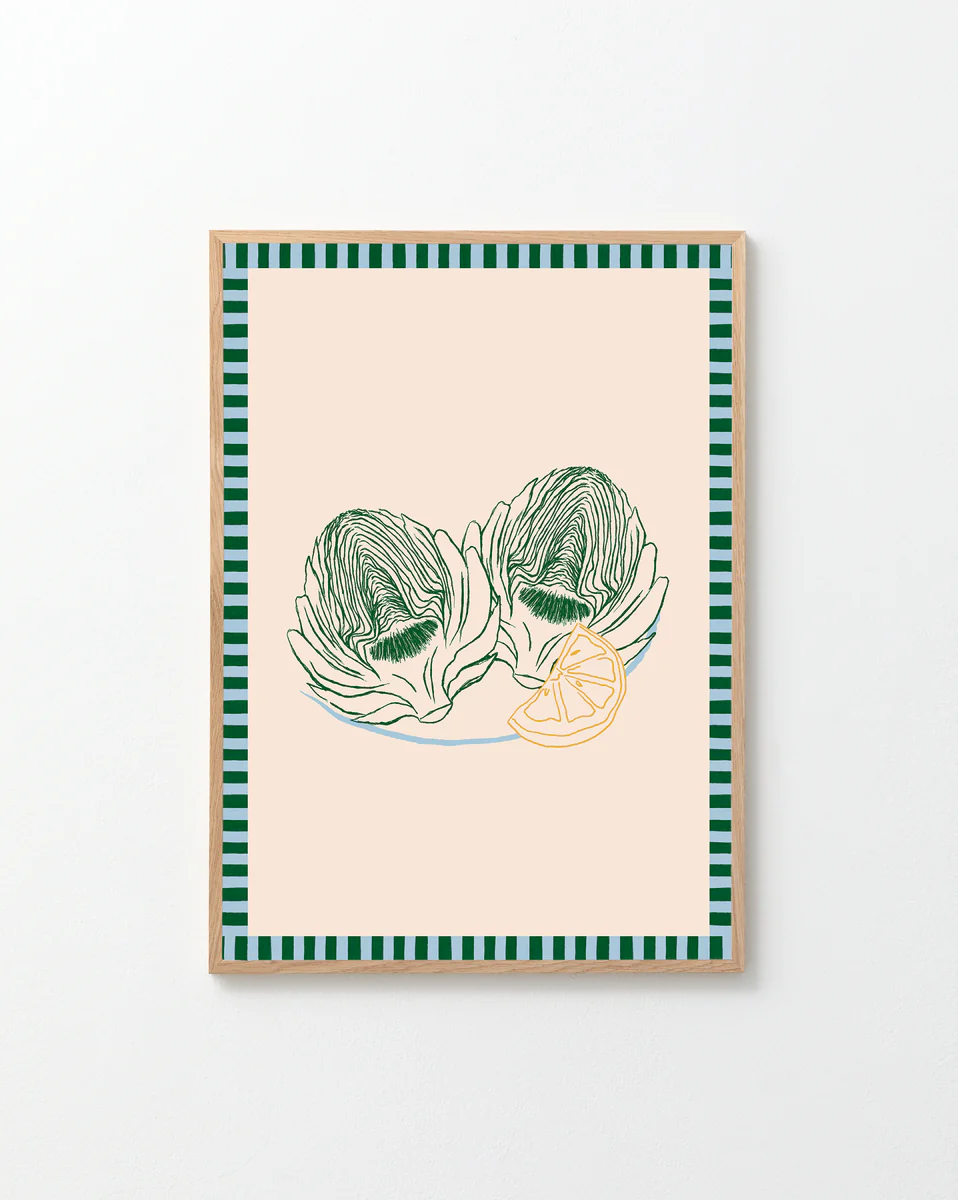 The Les Artichauts Poster has framed artwork inspired by a French market, showcasing two green artichokes and a lemon slice on beige, with stylish green and black striped borders, ideal for home decor.