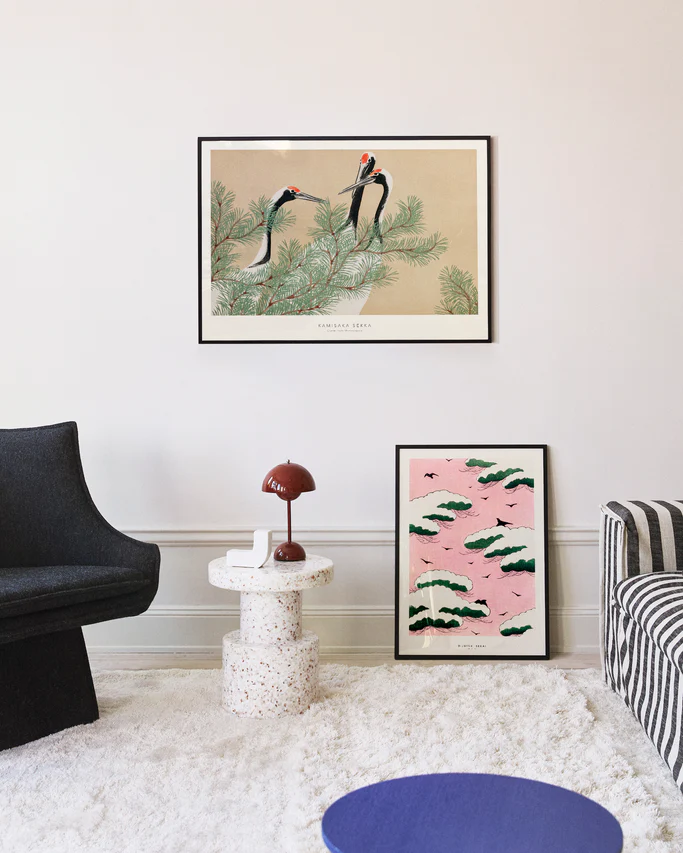 Living room with framed artwork on the wall, including a nature-themed print and a pink abstract design.