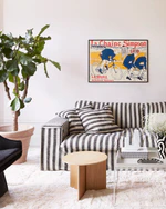 Living room with a striped sofa, coffee table, and decorative poster on the wall.