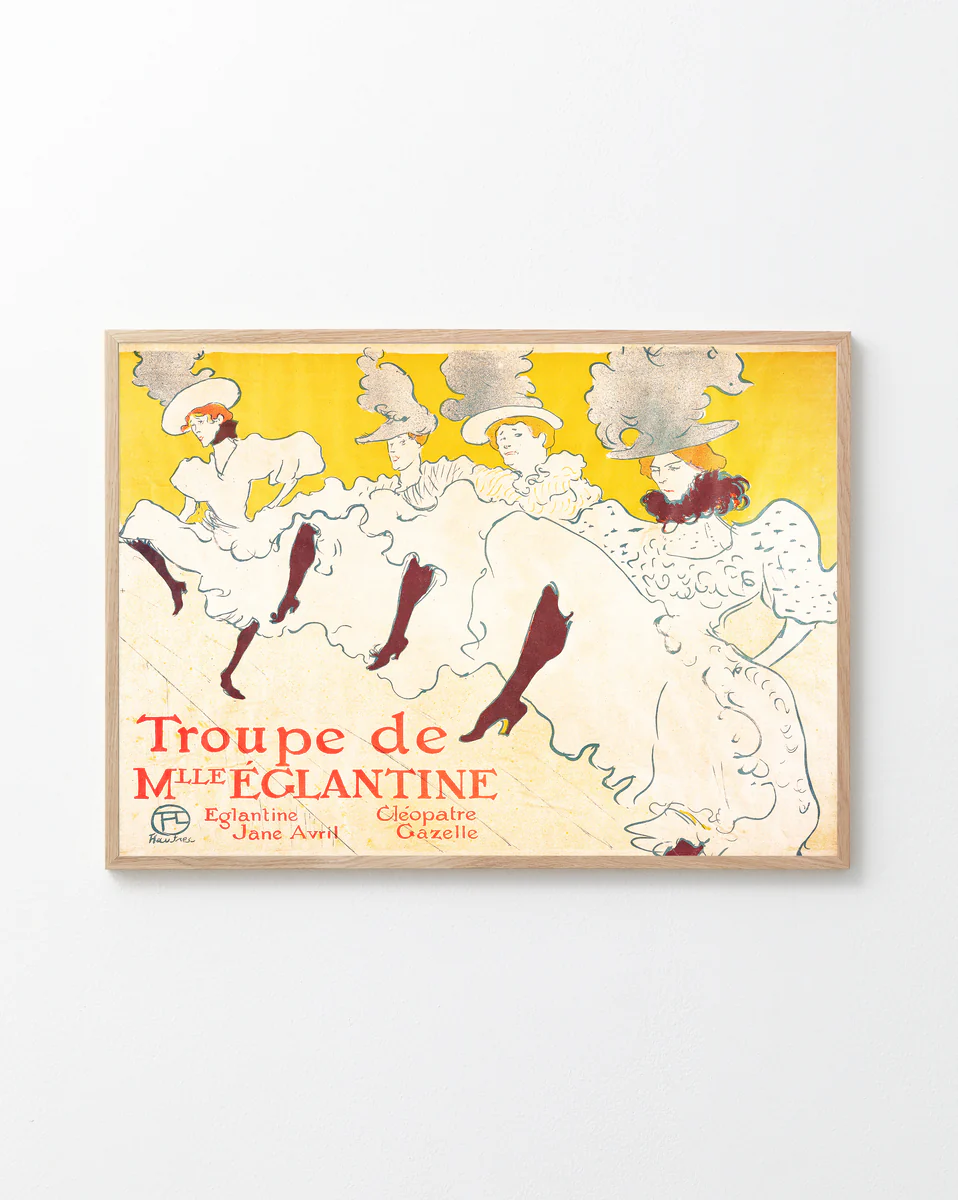 A framed poster titled La Troupe de Mademoiselle Eglantine by Henri de Toulouse-Lautrec features elegant dancers in flowing white dresses and elaborate hats against a bright yellow background, including performers Eglantine, Jane Avril, and Cléopâtre, evoking the Belle Époque era.