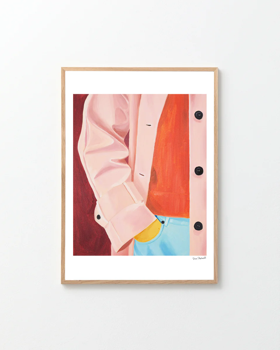 Framed artwork of a pink jacket and blue jeans against a red background.