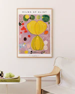 Framed Hilma af Klint artwork on a wall with a chair and small table in the foreground.