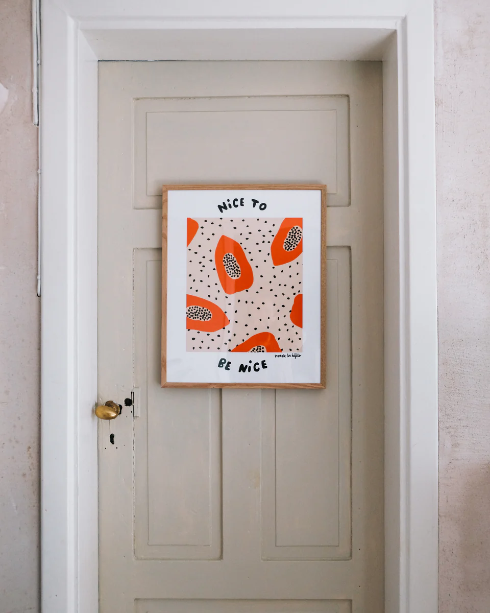 Poster Papaya No1 with oak frame hanging on a grey door.