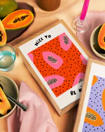 Poster Papaya No3 laying on a table with an orange tablecloth, you can hint poster Papaya No2. The table is decorated with papayas.