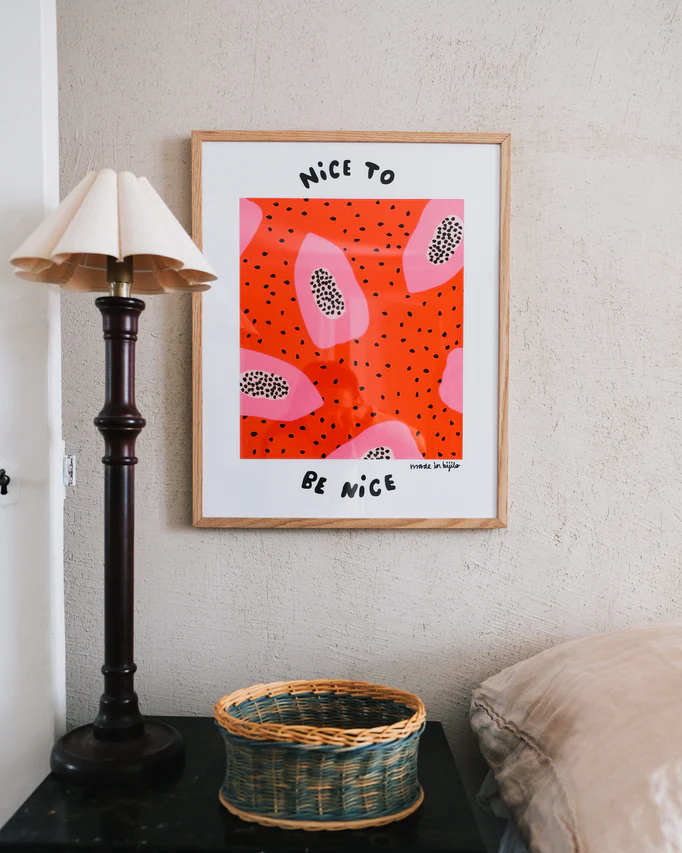 Papaya Poster No. 3 elegantly framed in oak, adorning the wall above a sleek sideboard. Accompanied by a stylish table lamp and a charming rattan basket.