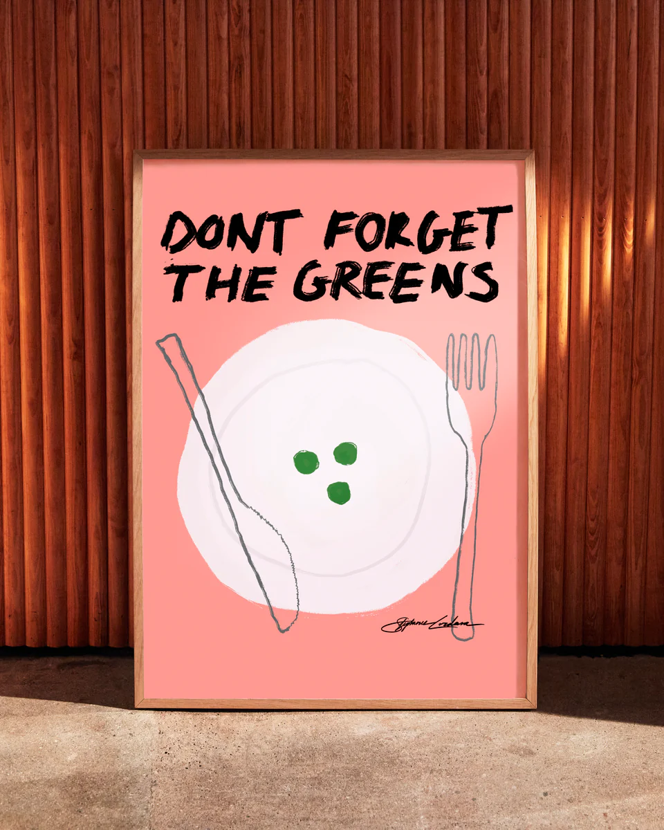 The Dont Forget the Greens Poster is a framed digital illustration featuring a pink background with a minimalist outline of a plate, fork, and knife. Three green circles rest on the plate beneath the bold black text DONT FORGET THE GREENS, making it ideal for quirky home decor.