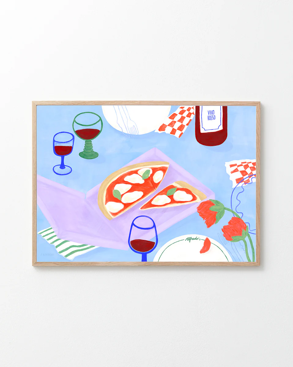 Frauke Schyrokis Pizza for Three Poster depicts a lively table scene with pizza slices, red wine glasses, and a bottle amongst vibrant red flowers, set against a blue backdrop. The wooden-framed wall art is embellished with basil and cheese for added charm.