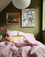 Bedroom with green walls, pink bedding, and framed artwork.
