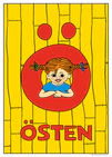 Pippi peeks through a big red Ö against a yellow wooden wall. Name: Östen. 