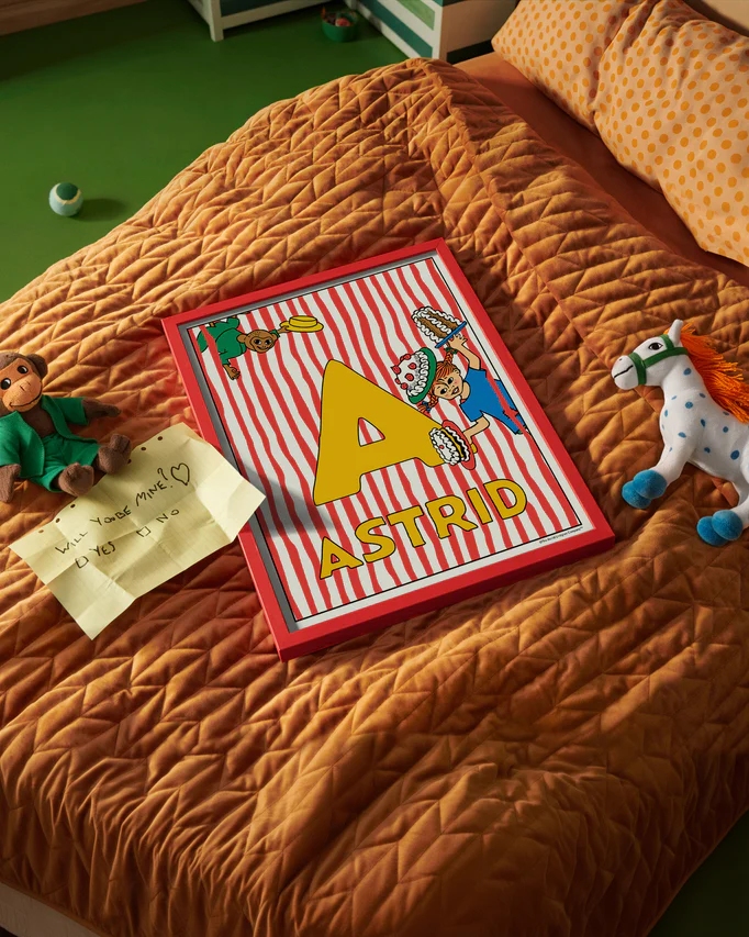 Pippi Longstocking name poster with the letter A and the name Astrid, placed on a neatly made bed in a bright kids’ room.