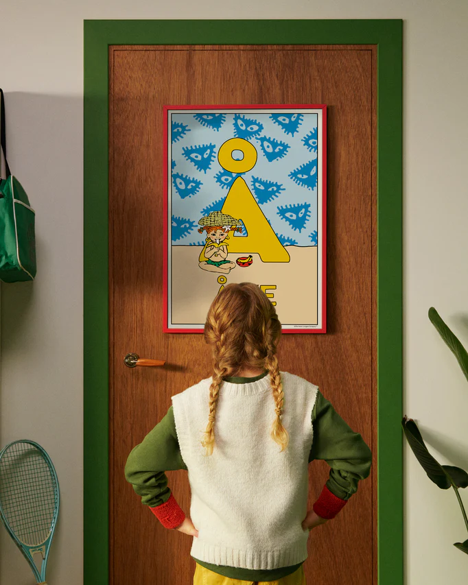Pippi Longstocking personalised poster featuring the letter Å hanging on a door, with a child curiously looking at the artwork.