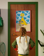 Pippi Longstocking personalised poster featuring the letter Å hanging on a door, with a child curiously looking at the artwork.