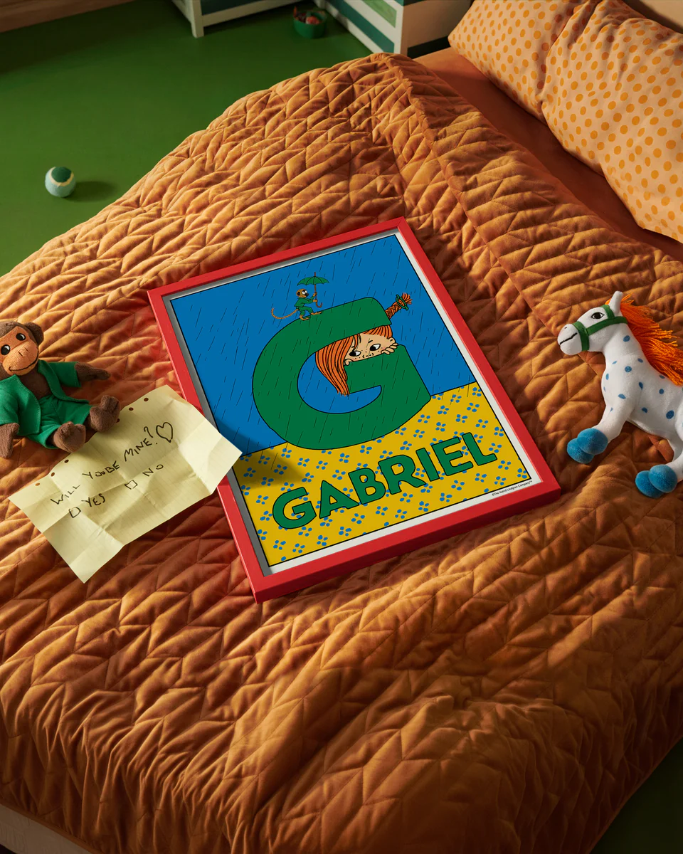 Pippi Longstocking name poster with the letter G and the name Gabriel, placed on a neatly made bed in a bright kids’ room.