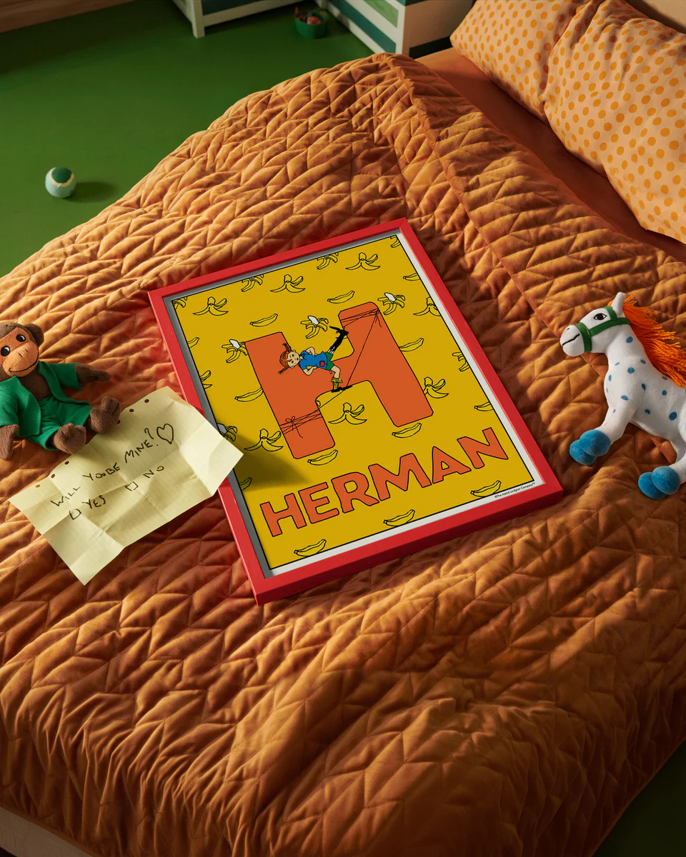 Pippi Longstocking name poster with the letter H and the name Herman, placed on a neatly made bed in a bright kids’ room.