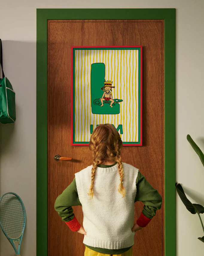 Pippi Longstocking personalised poster featuring the letter L hanging on a door, with a child curiously looking at the artwork.