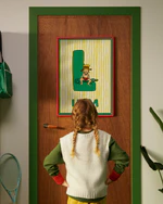 Pippi Longstocking personalised poster featuring the letter L hanging on a door, with a child curiously looking at the artwork.