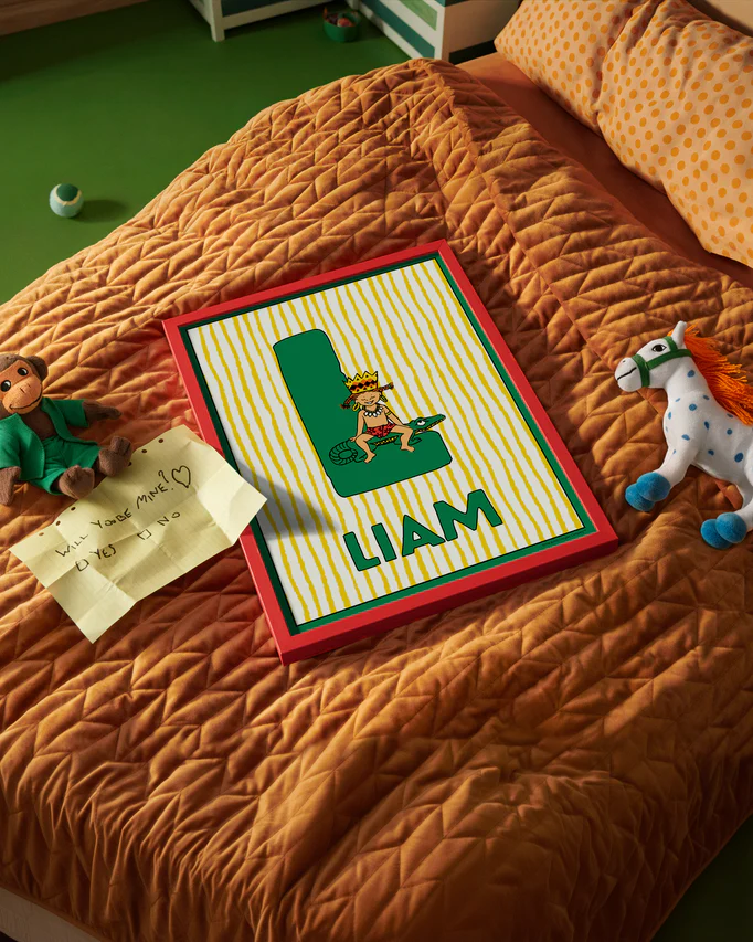 Pippi Longstocking name poster with the letter L and the name Liam, placed on a neatly made bed in a bright kids’ room.