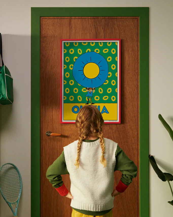 Pippi Longstocking personalised poster featuring the letter O hanging on a door, with a child curiously looking at the artwork.