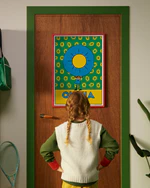 Pippi Longstocking personalised poster featuring the letter O hanging on a door, with a child curiously looking at the artwork.