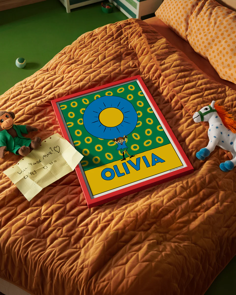 Pippi Longstocking name poster with the letter O and the name Olivia, placed on a neatly made bed in a bright kids’ room.