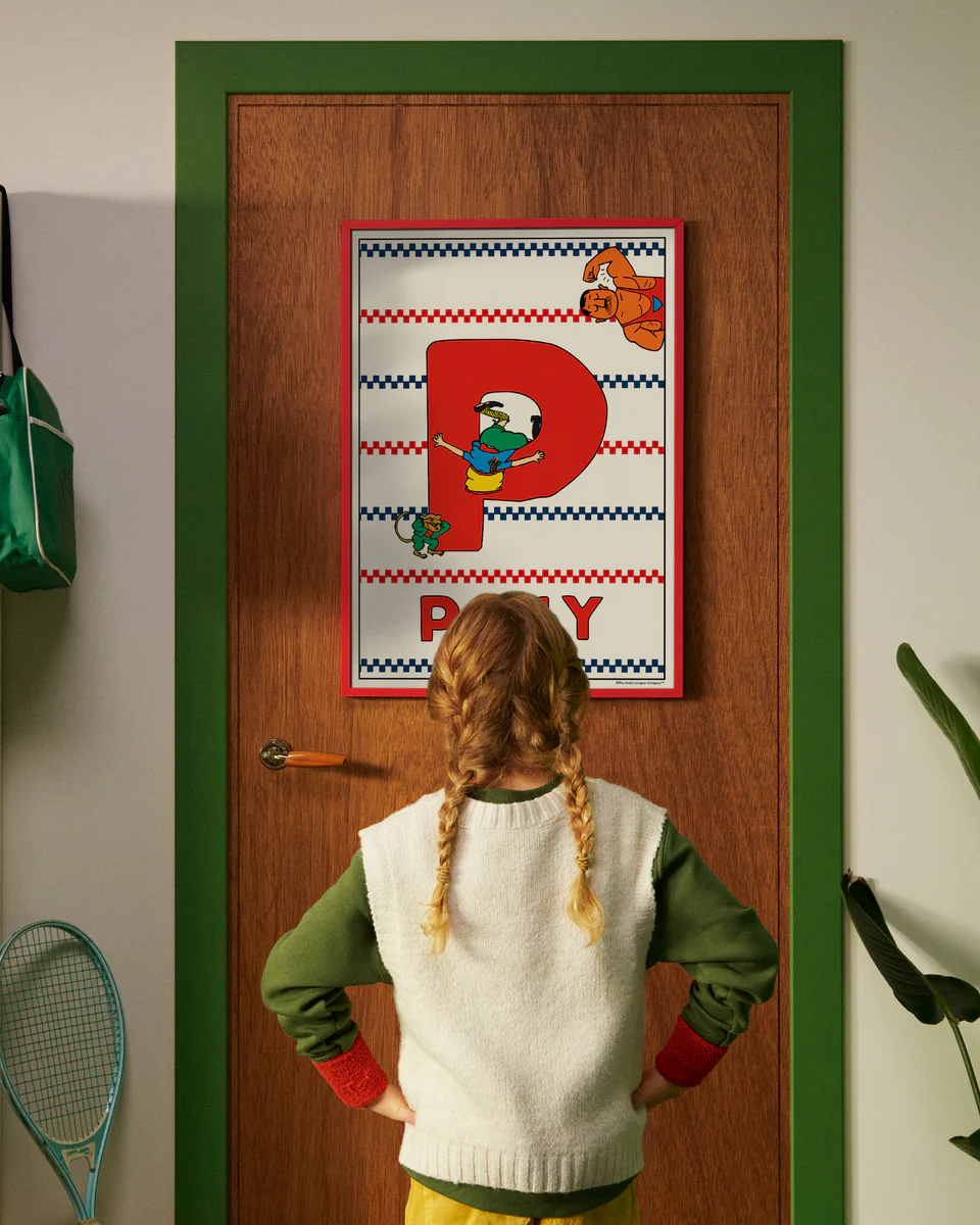 Pippi Longstocking personalised poster featuring the letter P hanging on a door, with a child curiously looking at the artwork.