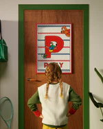 Pippi Longstocking personalised poster featuring the letter P hanging on a door, with a child curiously looking at the artwork.