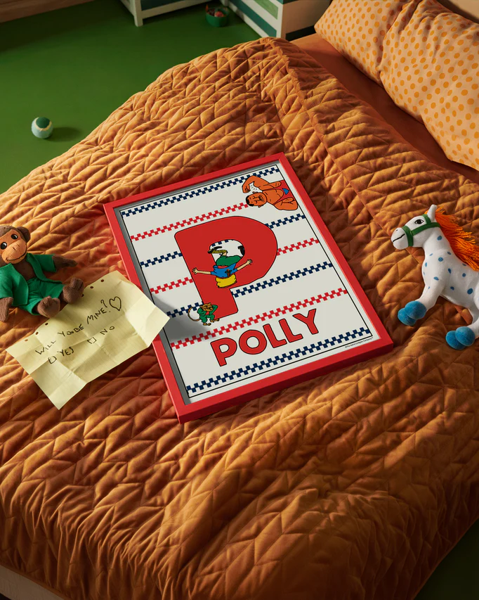 Pippi Longstocking name poster with the letter P and the name Polly, placed on a neatly made bed in a bright kids’ room.