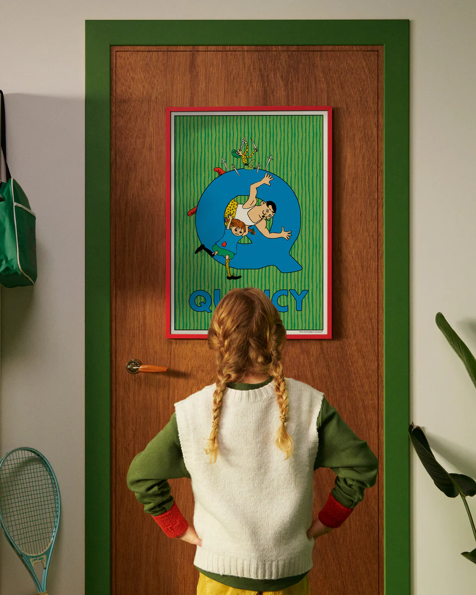 Pippi Longstocking personalised poster featuring the letter Q hanging on a door, with a child curiously looking at the artwork.