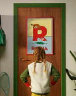 Pippi Longstocking personalised poster featuring the letter R hanging on a door, with a child curiously looking at the artwork.