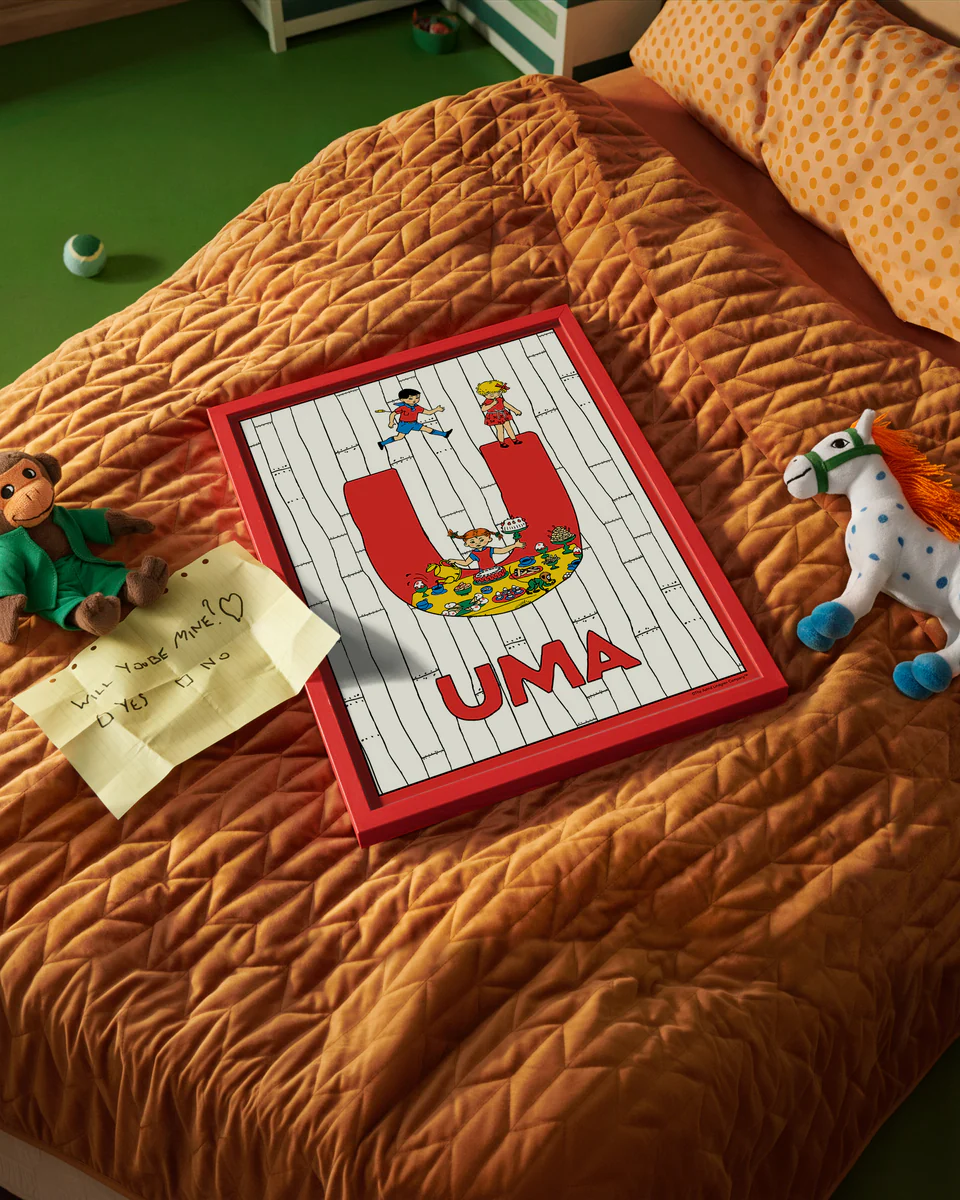Pippi Longstocking name poster with the letter U and the name Uma, placed on a neatly made bed in a bright kids’ room.