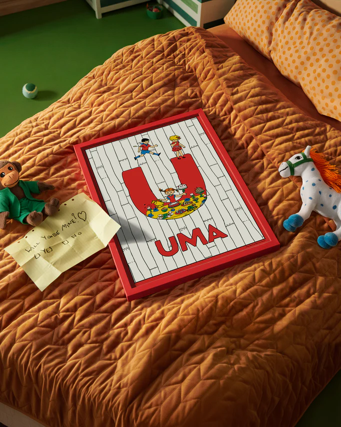 Pippi Longstocking name poster with the letter U and the name Uma, placed on a neatly made bed in a bright kids’ room.