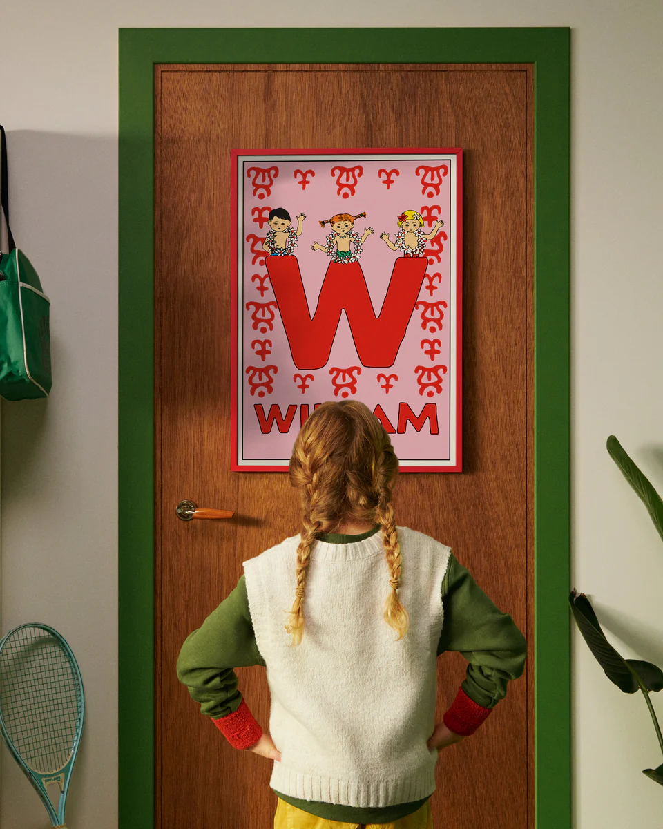 Pippi Longstocking personalised poster featuring the letter W hanging on a door, with a child curiously looking at the artwork.