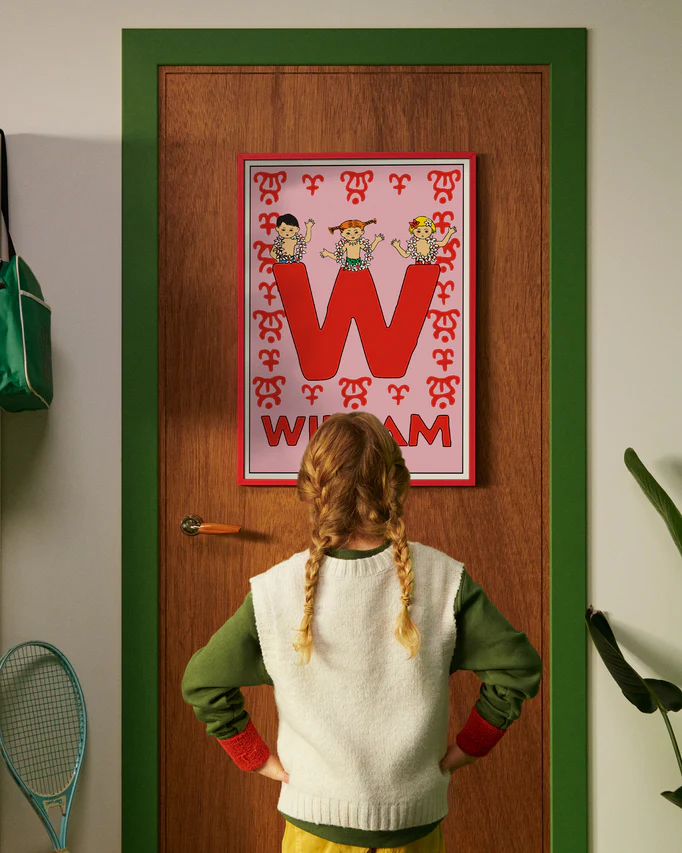 Pippi Longstocking personalised poster featuring the letter W hanging on a door, with a child curiously looking at the artwork.