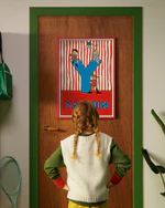 Pippi Longstocking personalised poster featuring the letter Y hanging on a door, with a child curiously looking at the artwork.