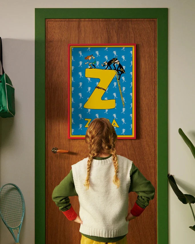 Pippi Longstocking personalised poster featuring the letter Z hanging on a door, with a child curiously looking at the artwork.