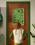A child looks at a Pippi Longstocking numbers poster hanging on a door.