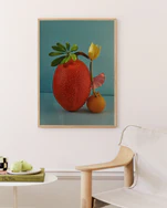 Poster featuring  a stilllife featuring fruits and a yellow tulip against a blue background in a oak frame set in a livingroom