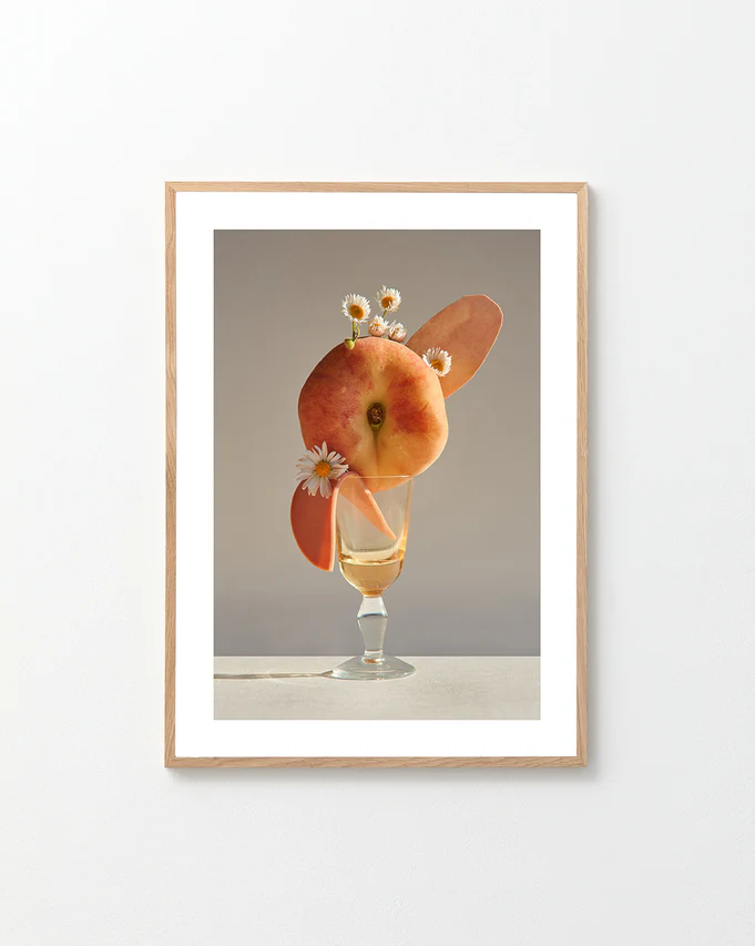 Poster featuring a stilllife photography of a drink adorned with a peach and flowers in a oak frame