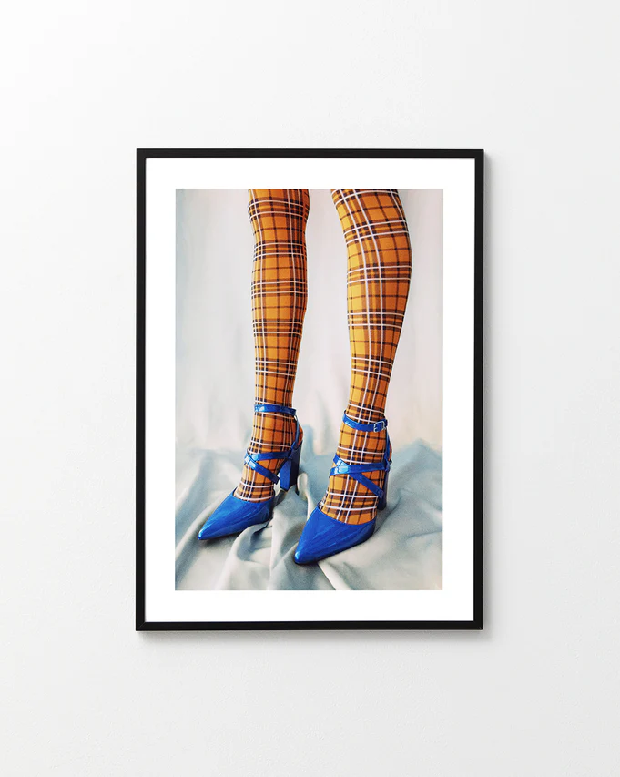 Legs wearing checkered mustard yellow stockings and high heeled blue sandals.
