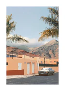 Orange city with palm trees located in a valley surrounded by high mountains.