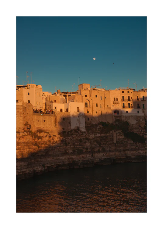 Italian town with old houses illuminated by the rays of sunshine during sunset.