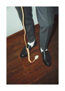 A man with dress shoes and slacks holding a yellow landline.