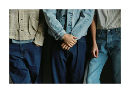 Three people dressed in different styles of denim.