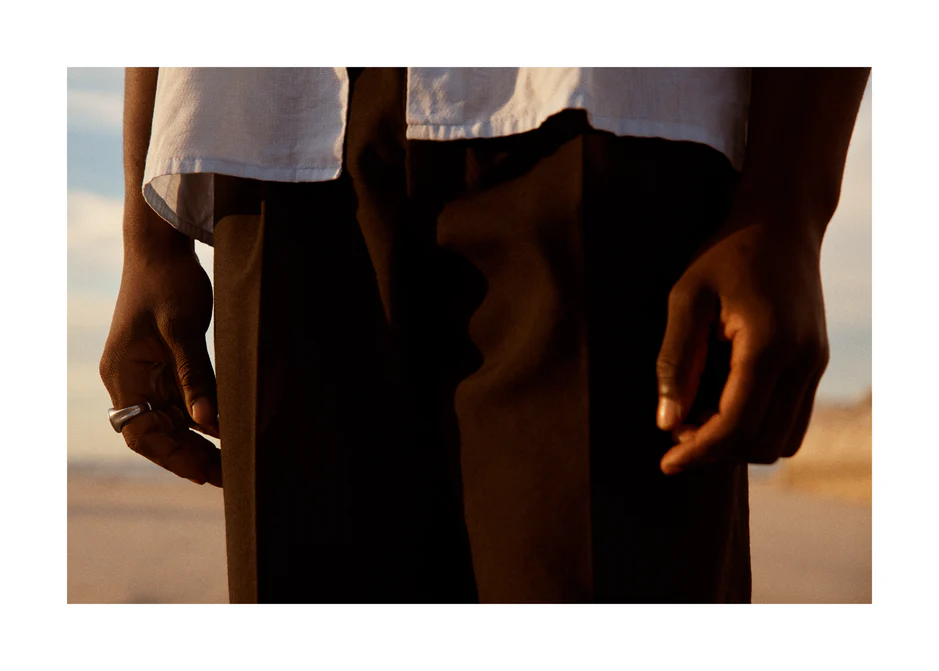 Man wearing white shirt and brown slacks.