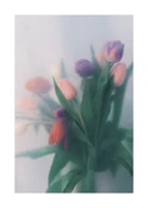 Blurry bouquet of colorful tulips with green leaves.