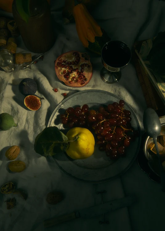Still life photograph of a sheet with different fruits and objects on it.