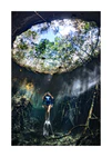 Female diver floating at the bottom of a sunlit cenote.